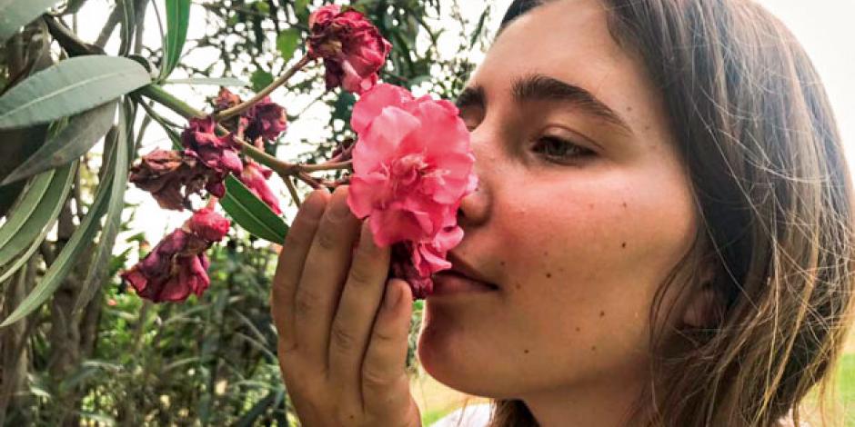 Ein Mädchen riecht an einer Blume